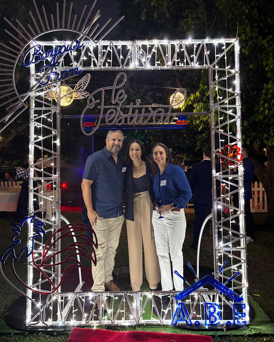 Cadre photo lumineux 2D avec trois visiteurs lors d'un événement festif